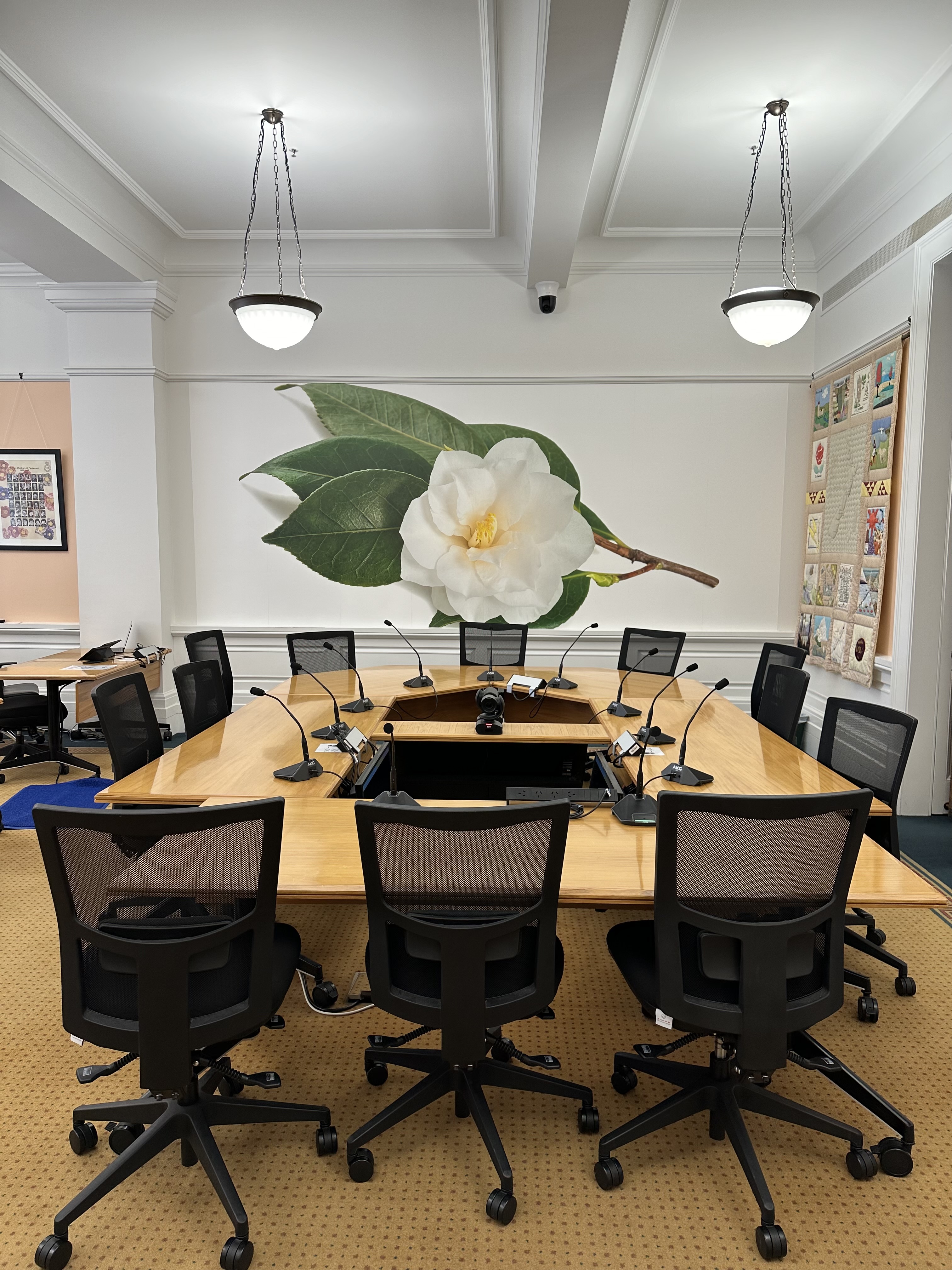 meeting room with artwork on walls and meeting table with video conference equipment setup