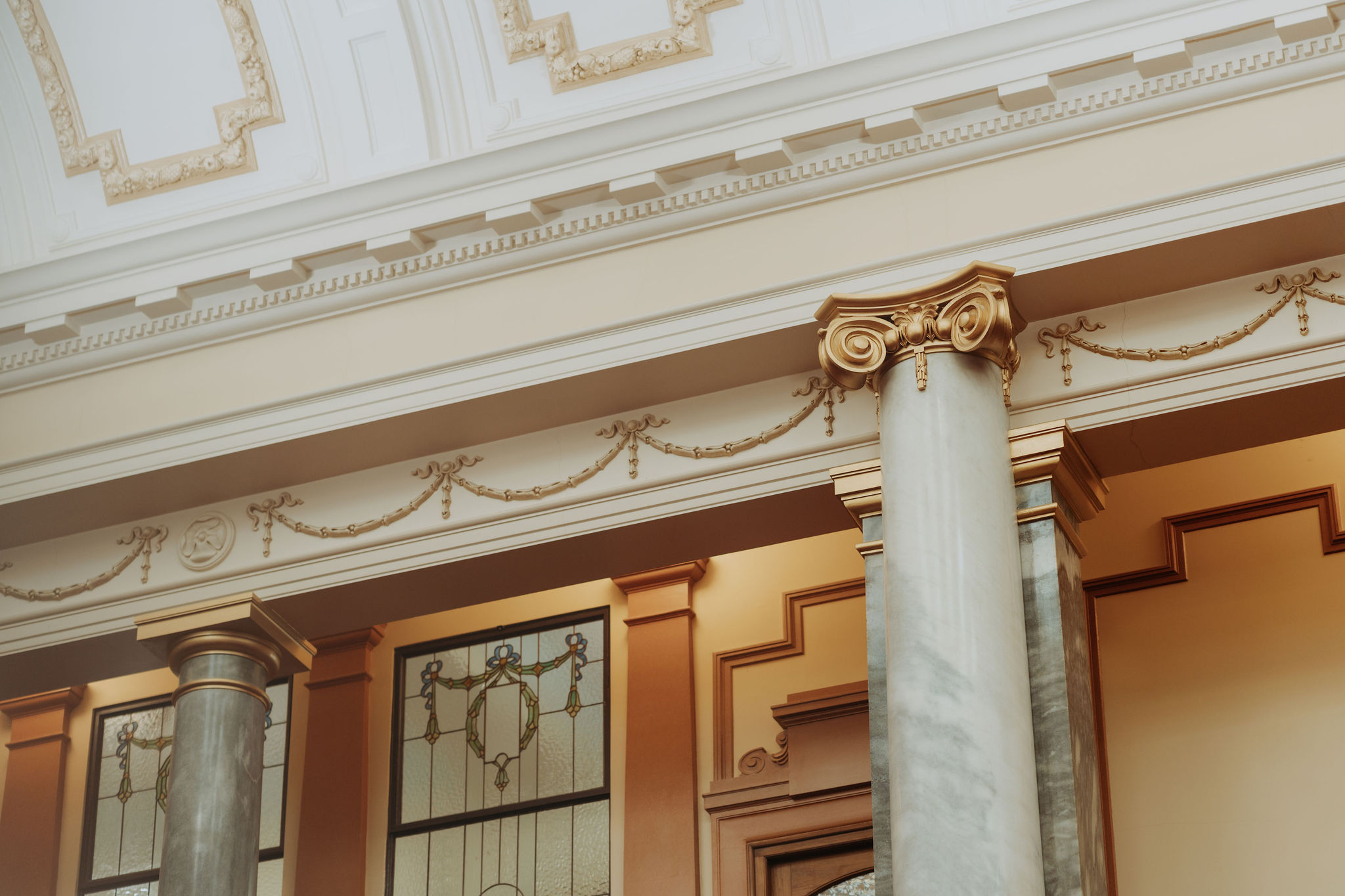 close up photo of Legislative Council Chamber architecture detail featuring gold gilded plaster and marble pillars