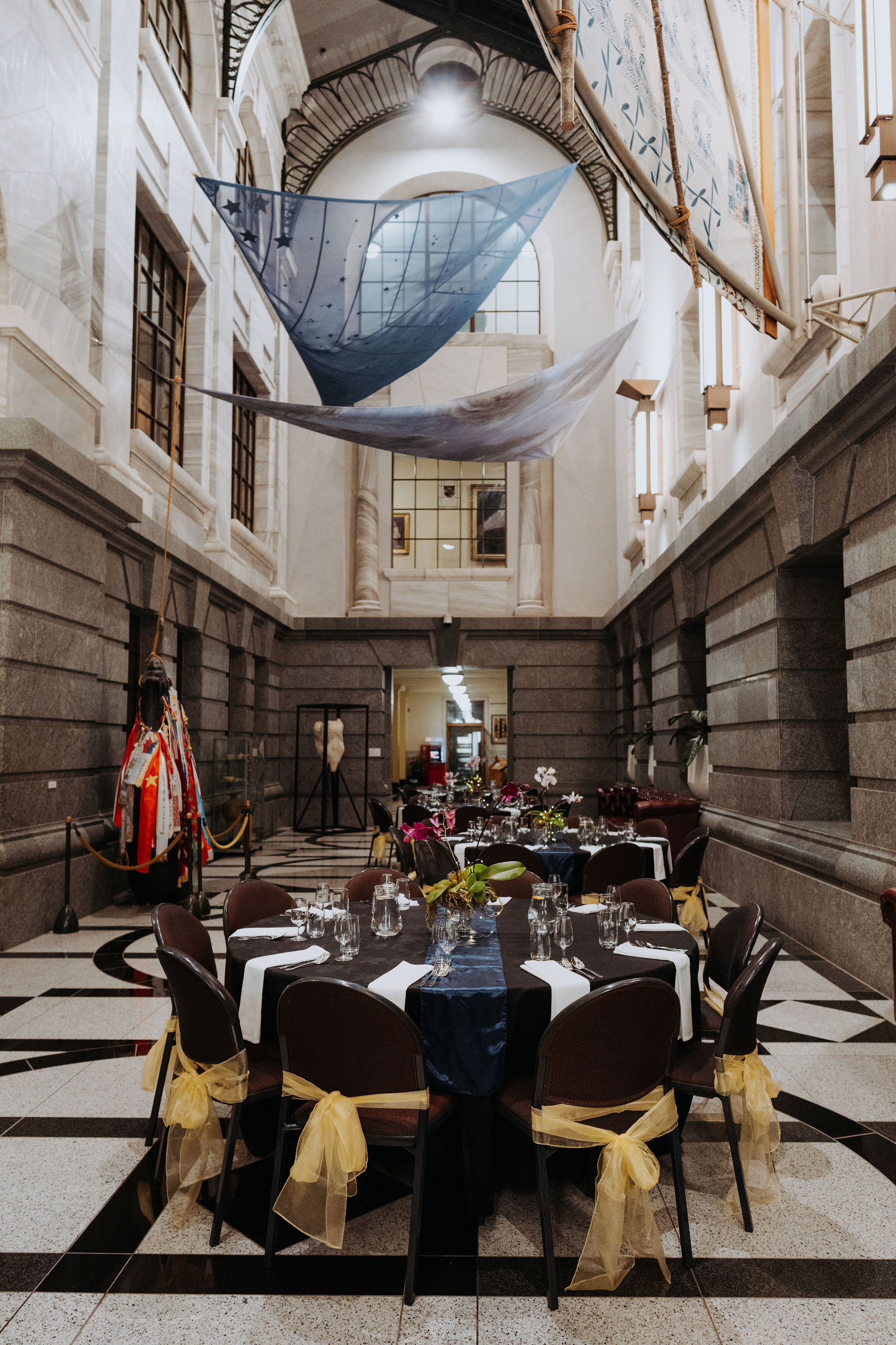 photo of multiple circular tables setup for dinner in Galleria with large hanging artwork above