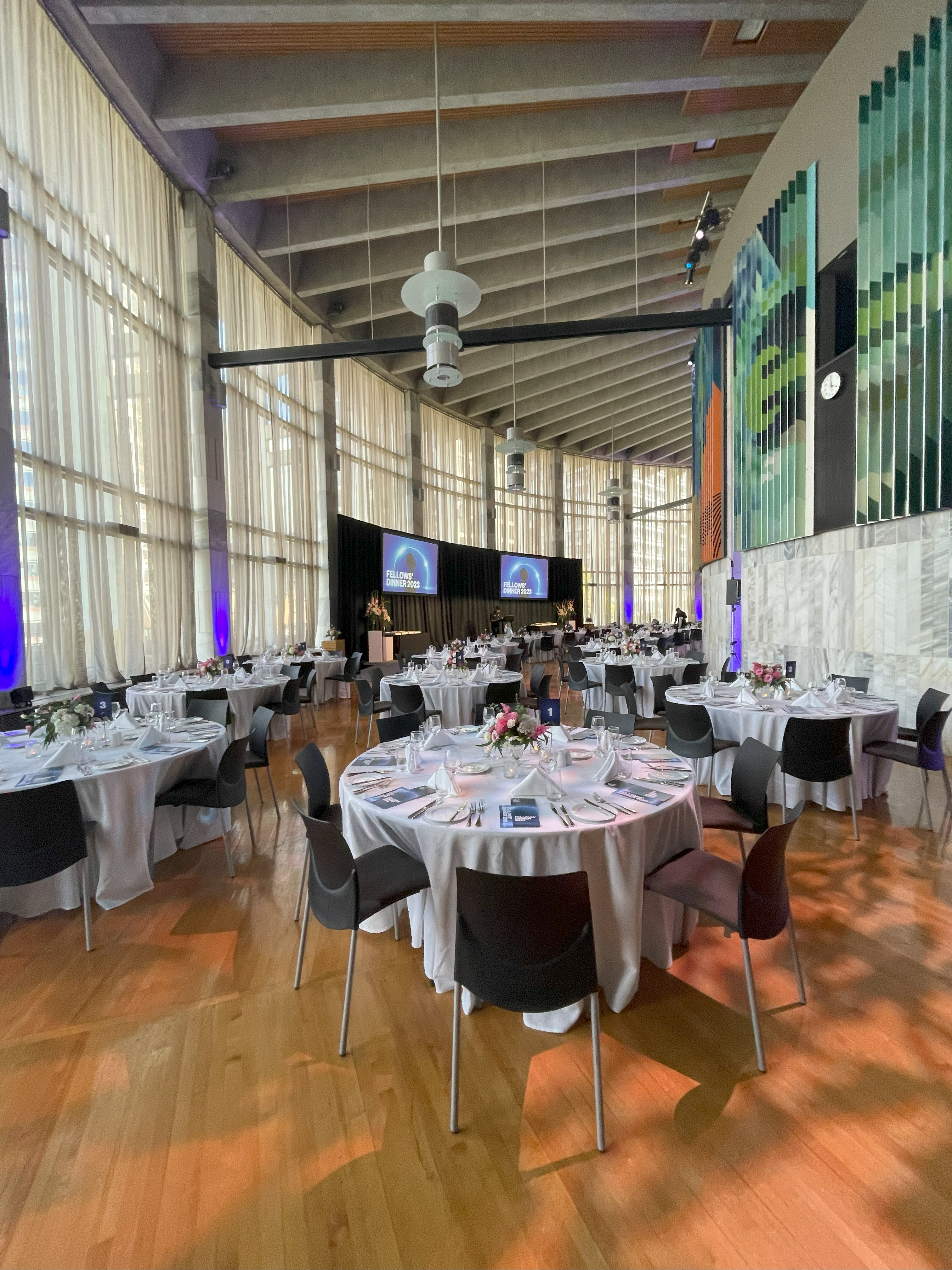 photo of round tables set up for dining with a stage in the background